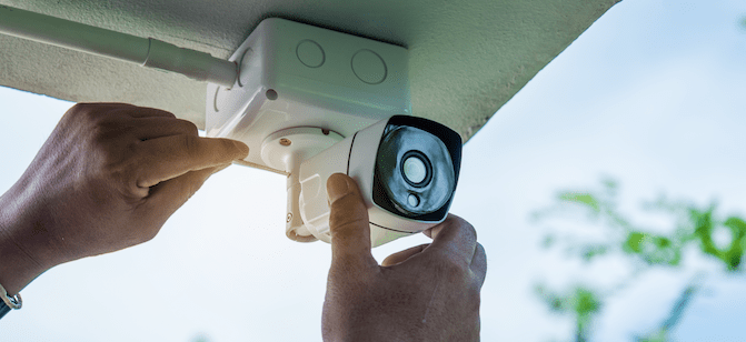 hands holding outdoor security camera